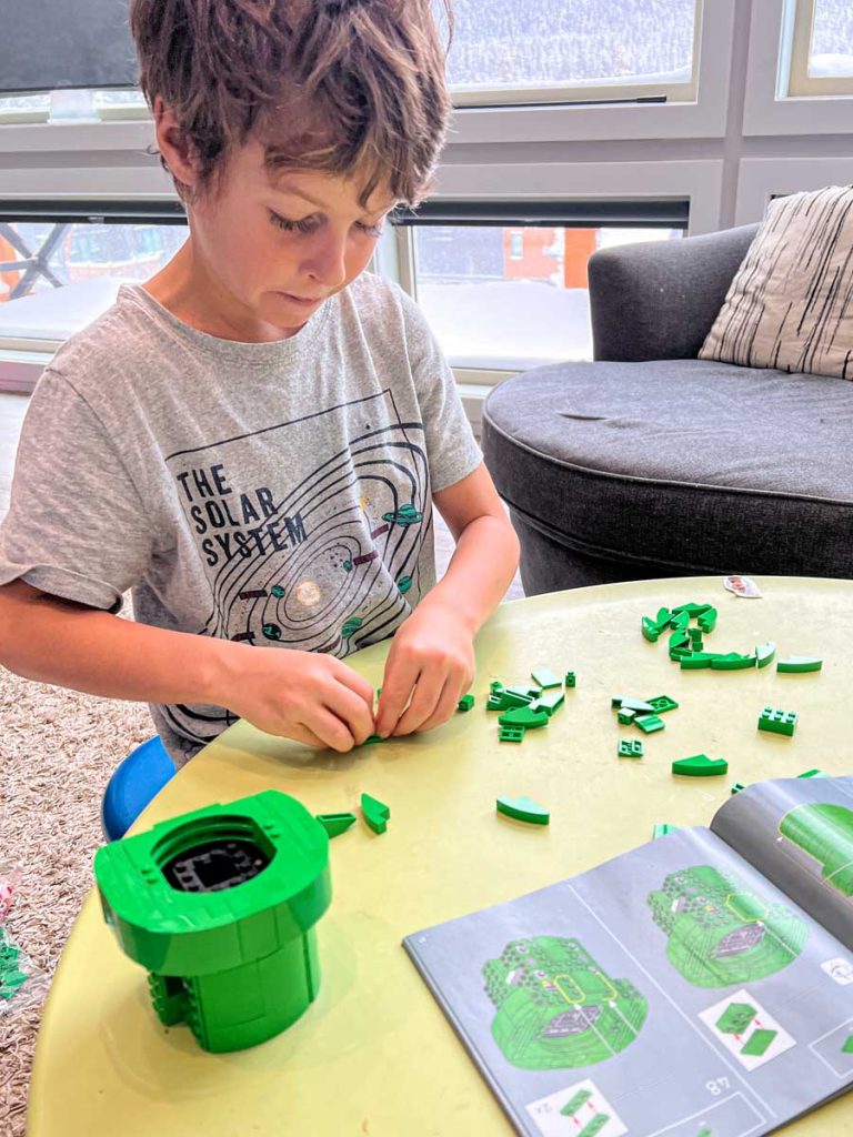 An 8-year old boy works on the Super Mario Piranha Plants Lego set (Lego set #71426).